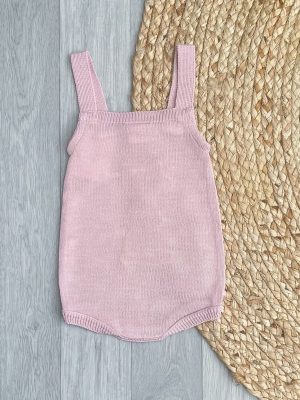 Back of blush pink bunny romper on brown wicker rug.