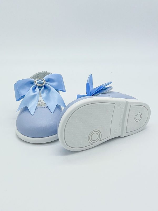Blue patent leather shoes with a large satin bow to the strap & diamanté ring to the centre on a white background facing to the front with one on it's side to show the sole.