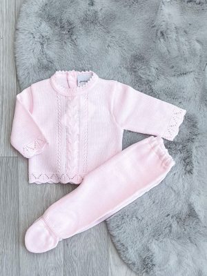 Flatlay of the pink scallop knitted two-piece on a grey fluffy rug.