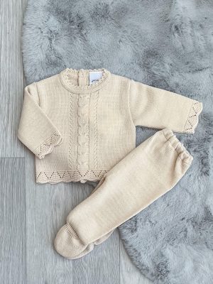 Flatlay of the beige scallop knitted two-piece on a grey fluffy rug.