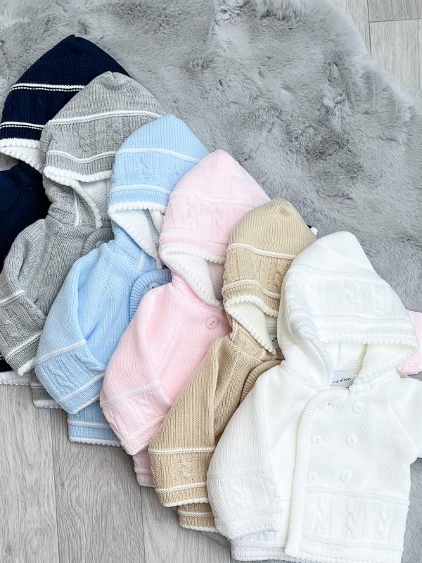 Flatlay of six knitted jackets; Navy, Grey, Blue, Pink, Beige & White on a grey fluffy rug